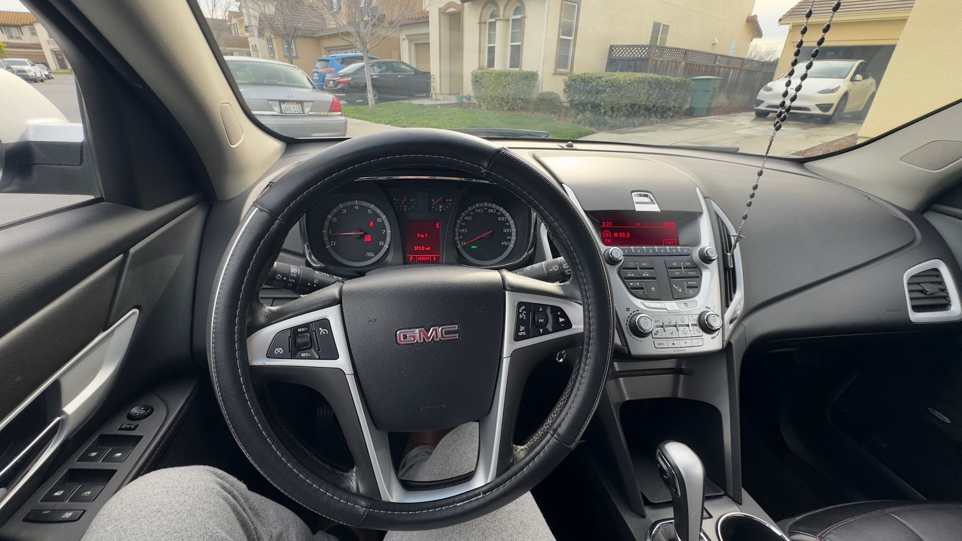A person is sitting in the driver 's seat of a gmc car.