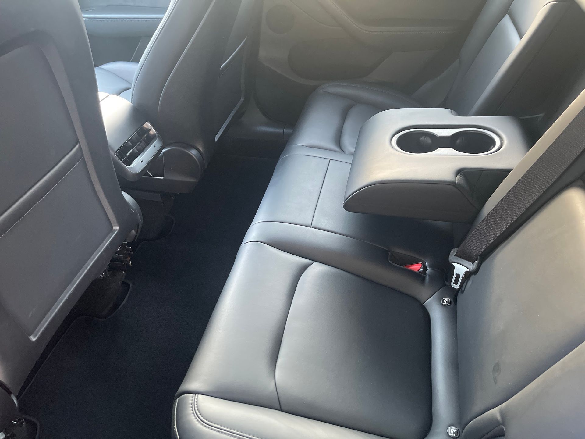 The back seat of a car with a cup holder