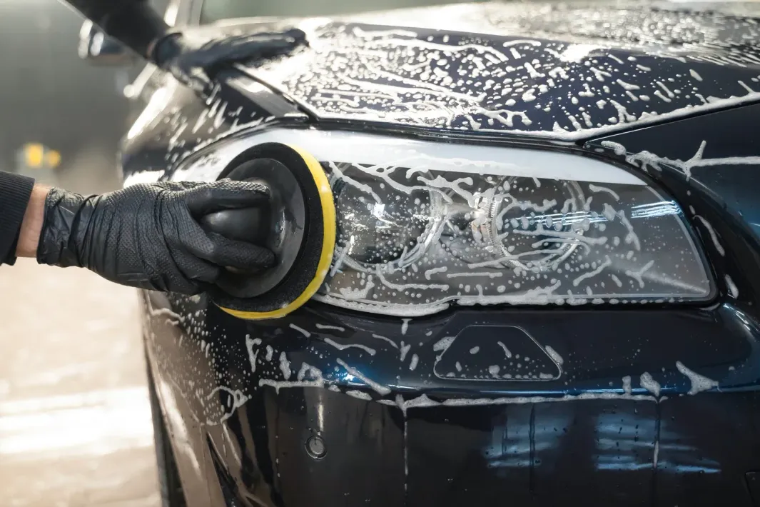 A car covered in foam is parked in a parking lot