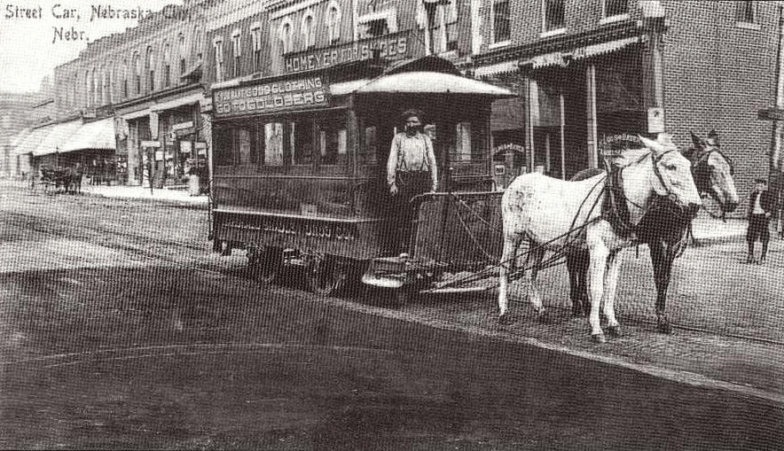 A black and white photo of a horse drawn trolley