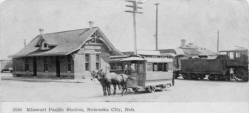 A black and white photo of a train pulled by horses