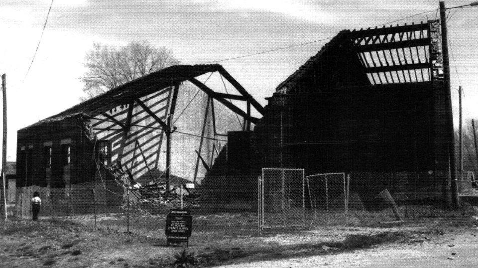 A black and white photo of a building that is being demolished