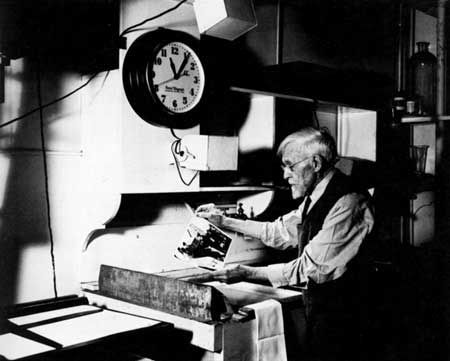 A black and white photo of a man sitting in front of a clock