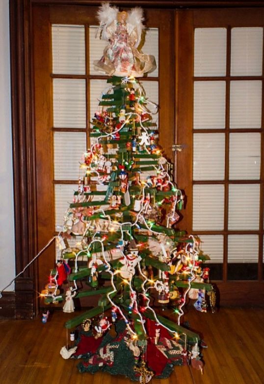 A decorated christmas tree in front of a door