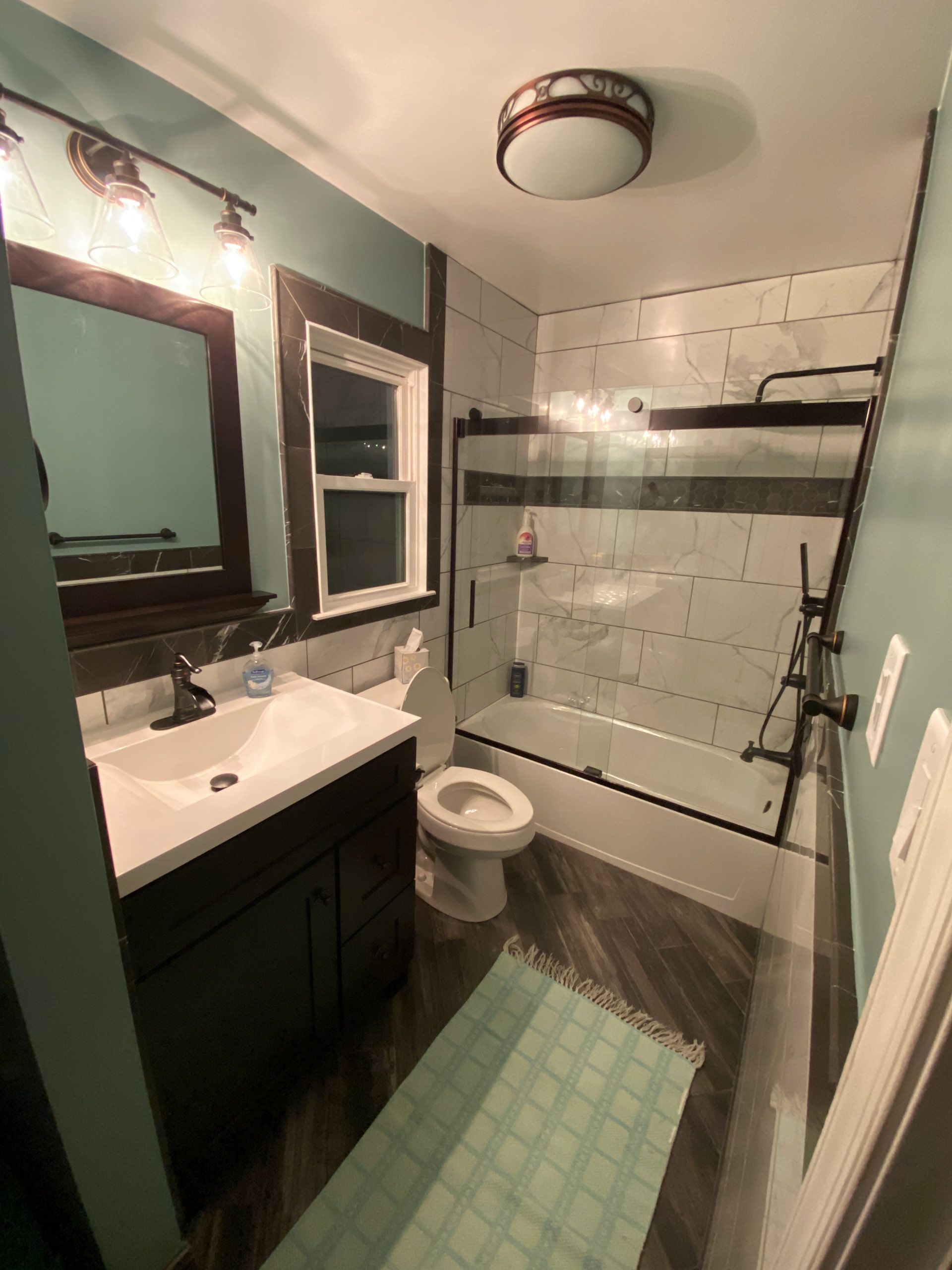A bathroom with a toilet , sink , and shower.