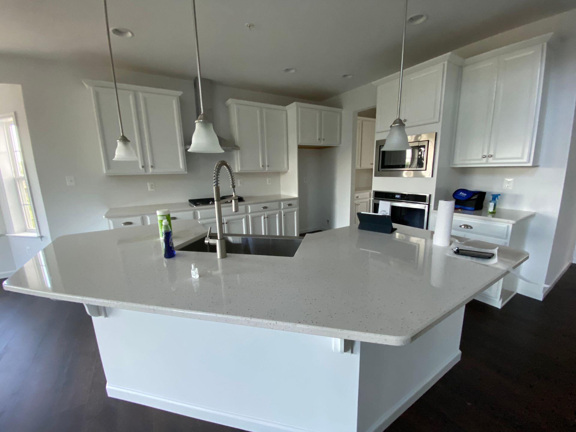 A kitchen with white cabinets and a large island in the middle.