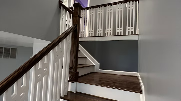 A staircase with wooden steps and a white railing in a house.