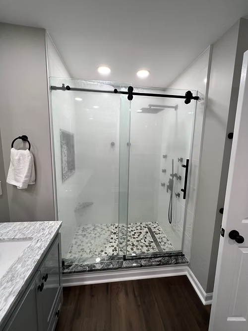 A bathroom with a sliding glass shower door and a sink.