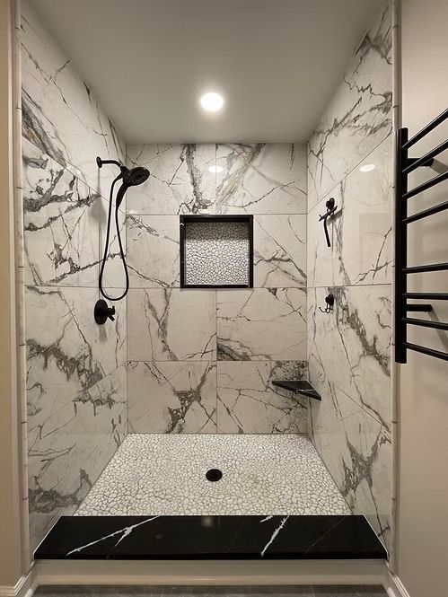 A bathroom with marble tiles and a walk in shower.