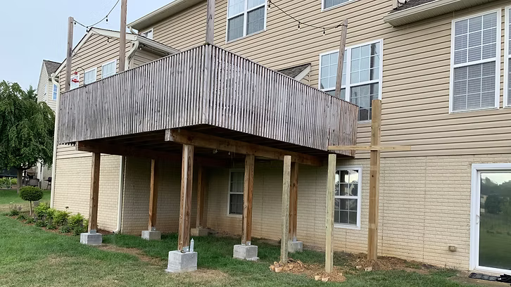 A large house with a wooden deck in front of it.