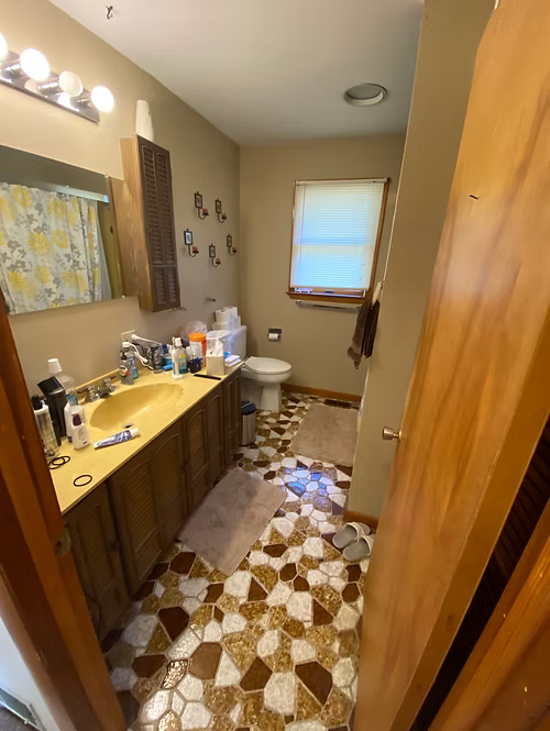 A bathroom with a sink , toilet and mirror.