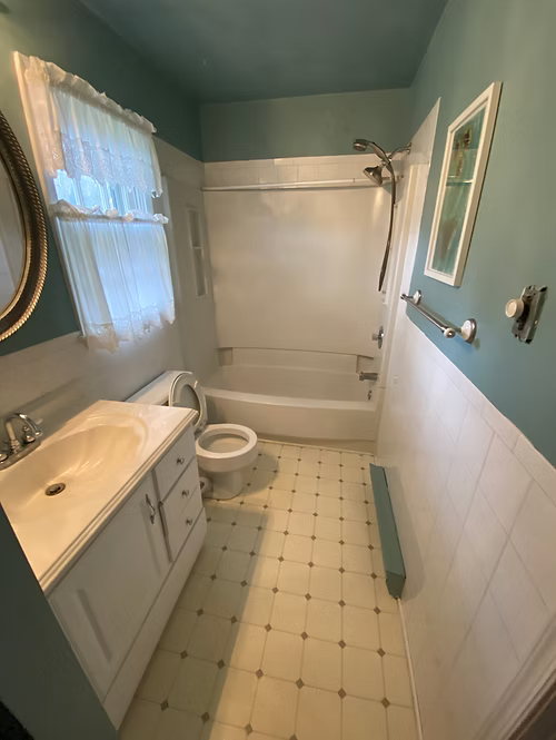A bathroom with a sink , toilet , tub and shower.