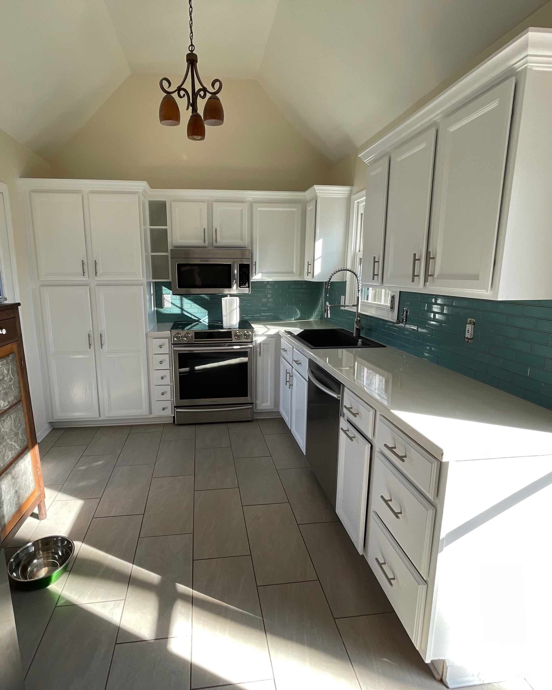 A kitchen with white cabinets and stainless steel appliances is being remodeled.