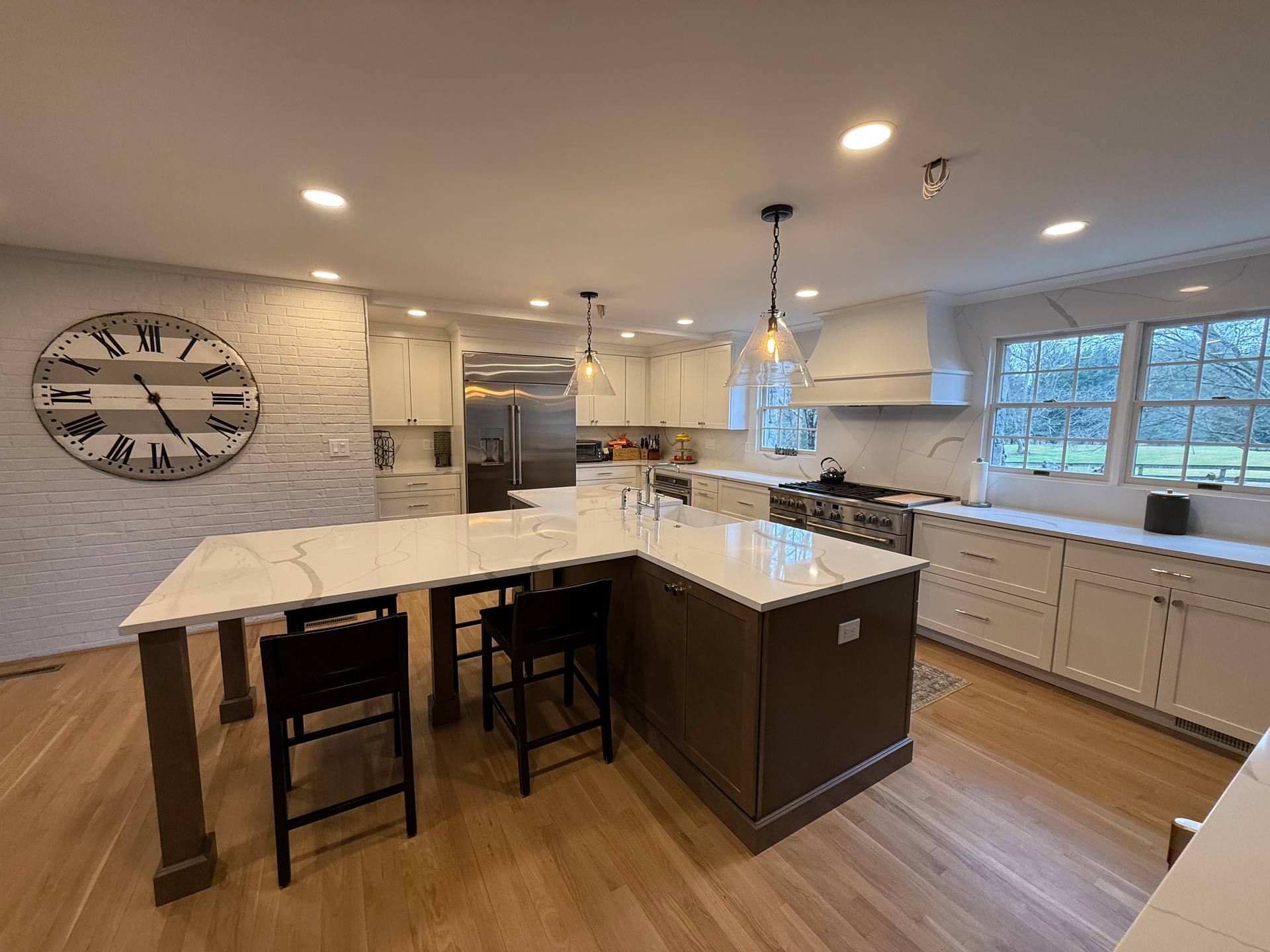 A kitchen with a large island and a clock on the wall.