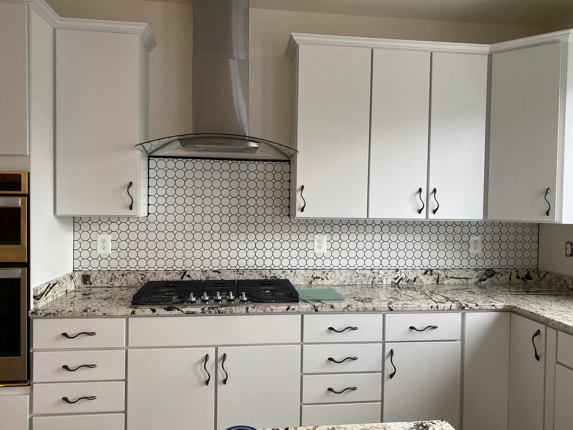 A kitchen with white cabinets and granite counter tops