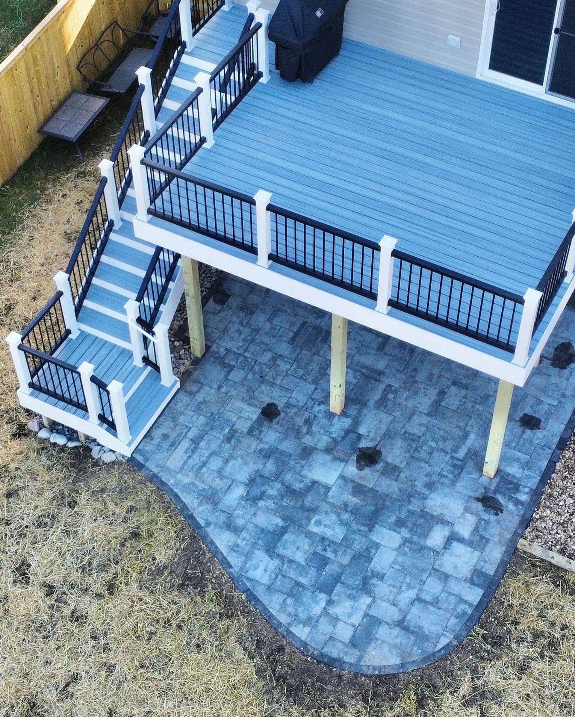 An aerial view of a blue deck with stairs and a patio.