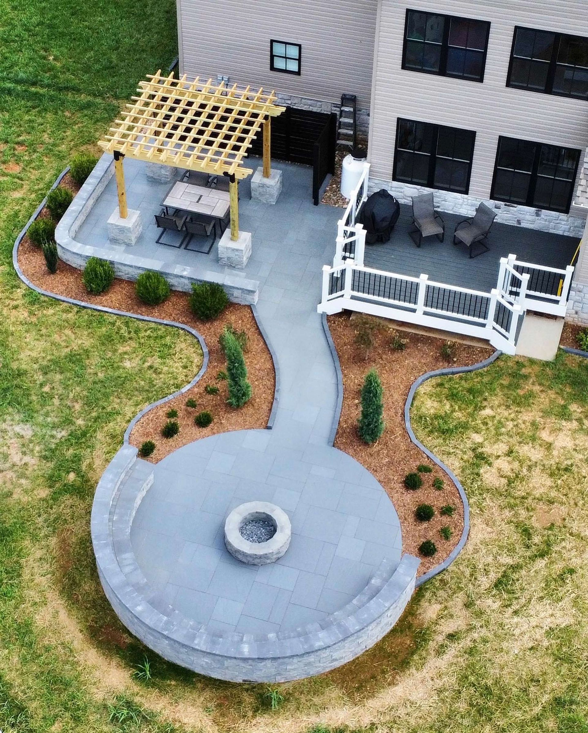 An aerial view of a patio with a fire pit and a pergola.