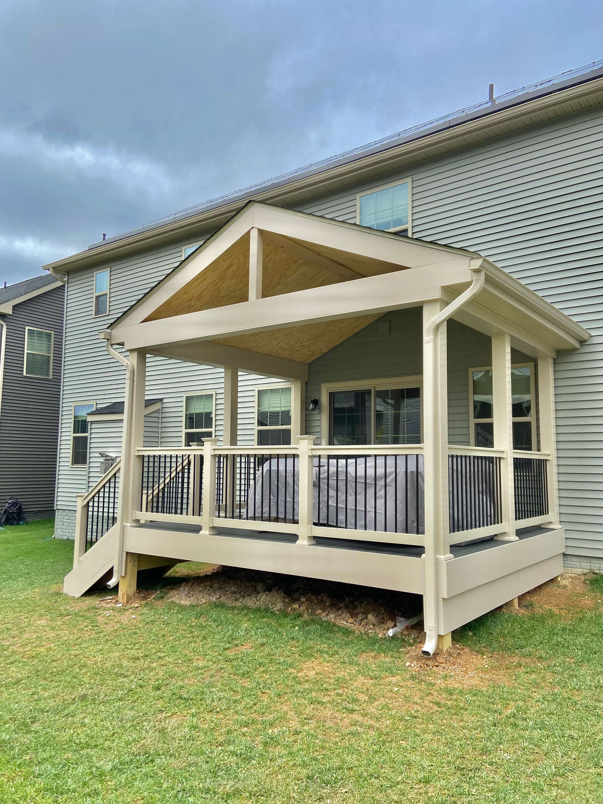 A screened in porch is sitting in the backyard of a house.