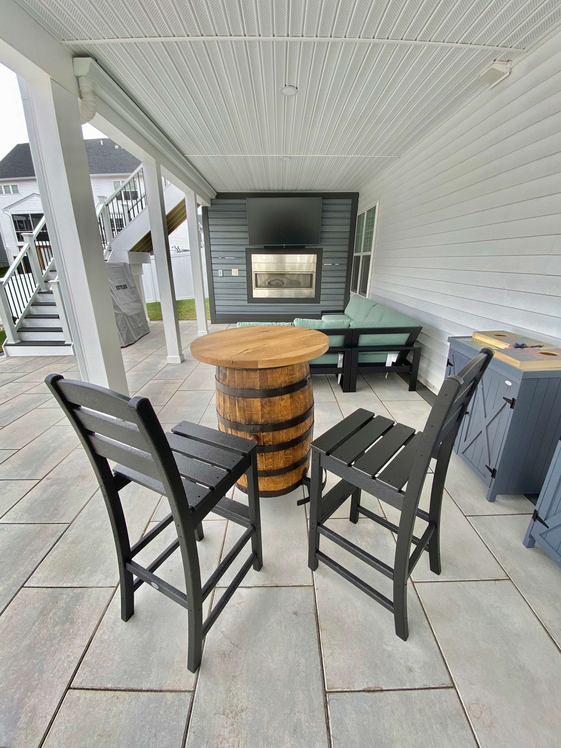A patio with two chairs and a table made out of a barrel