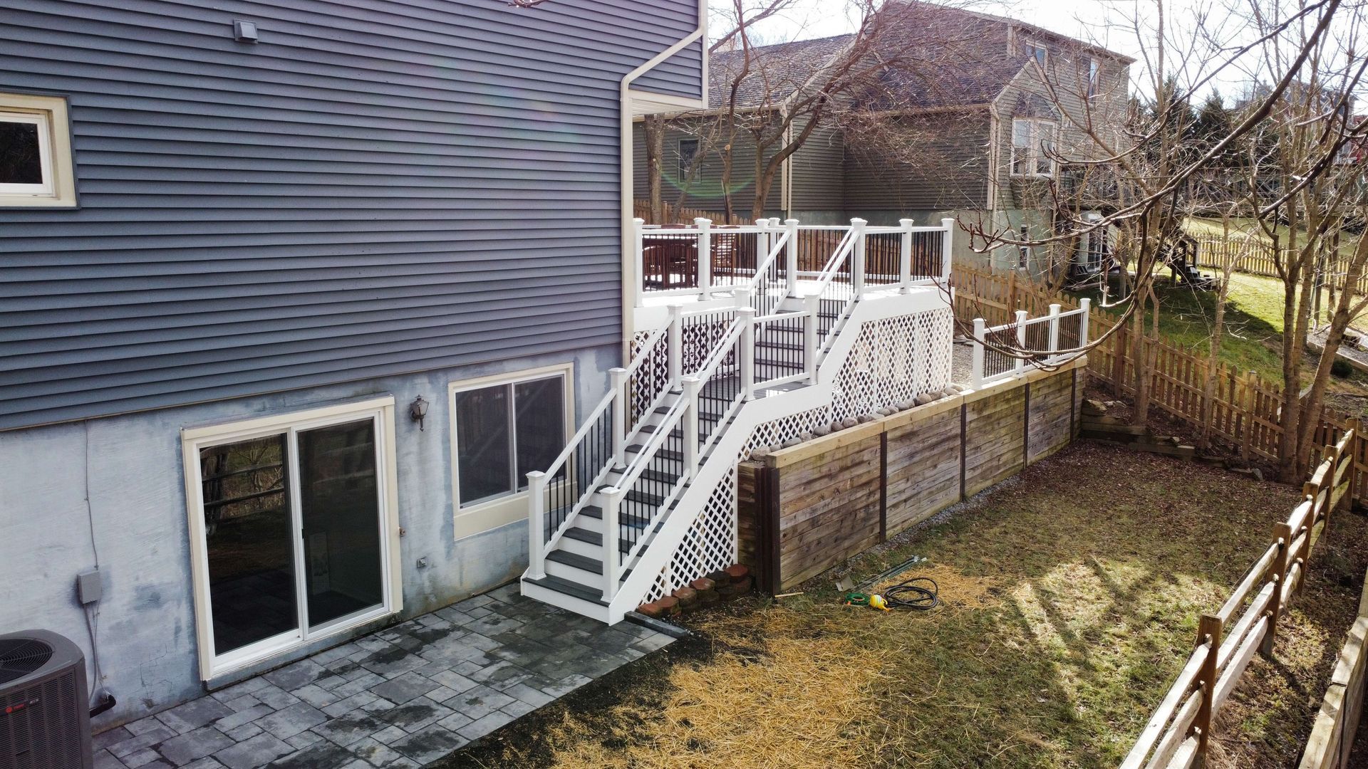 A house with a large deck and stairs in the backyard.