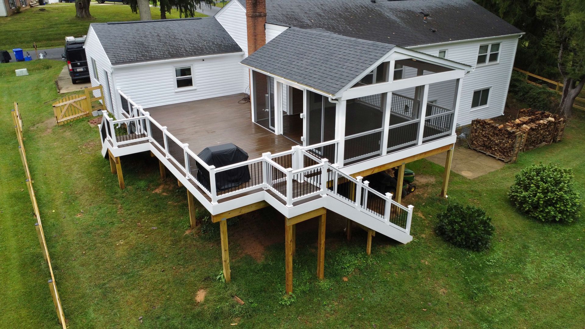 An aerial view of a house with a screened in porch and deck.