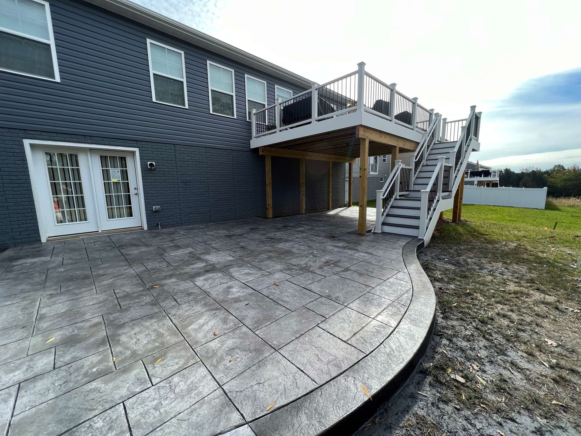 A large house with a large deck and stairs.