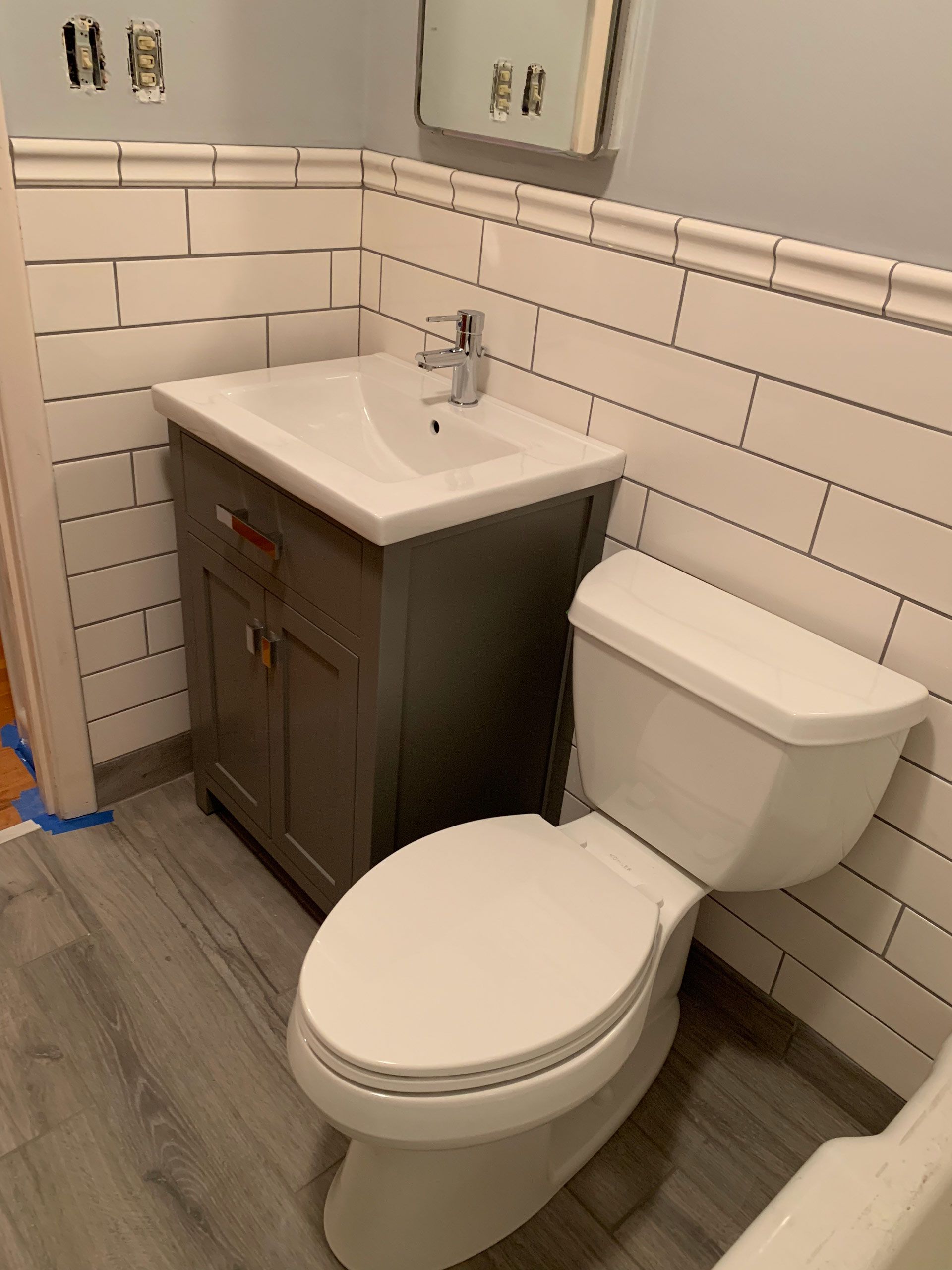 A bathroom with a toilet , sink and mirror