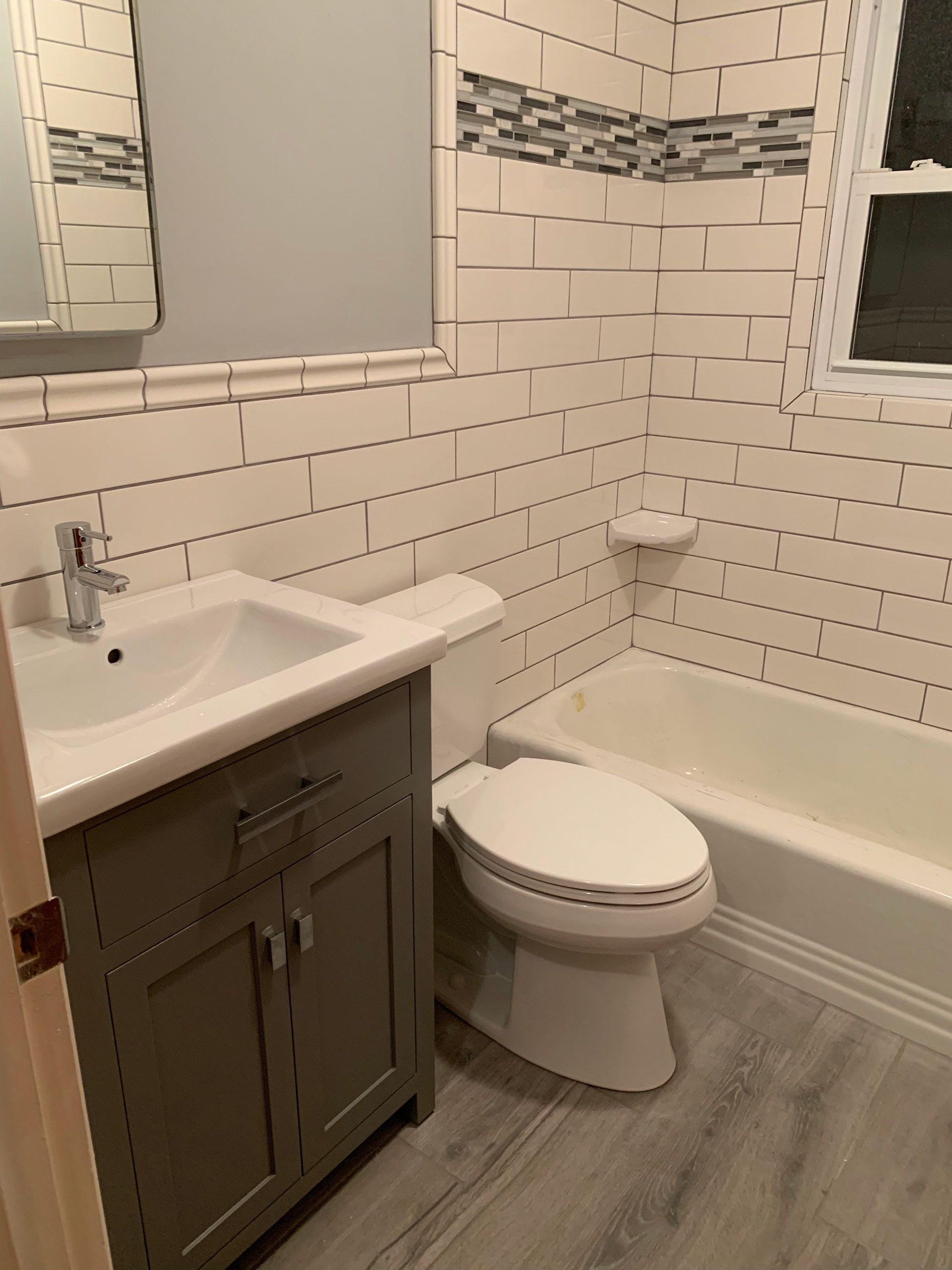 A bathroom with a toilet , sink , and bathtub.