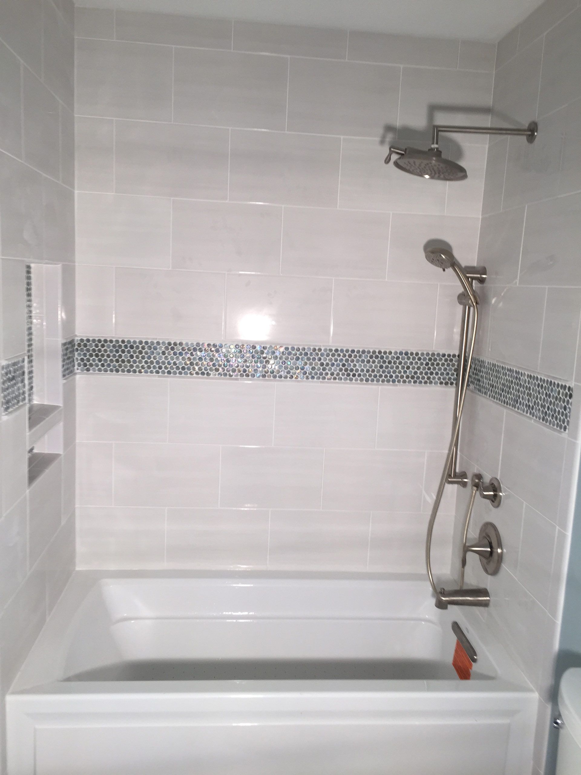 A bathroom with a bathtub , shower , and toilet.