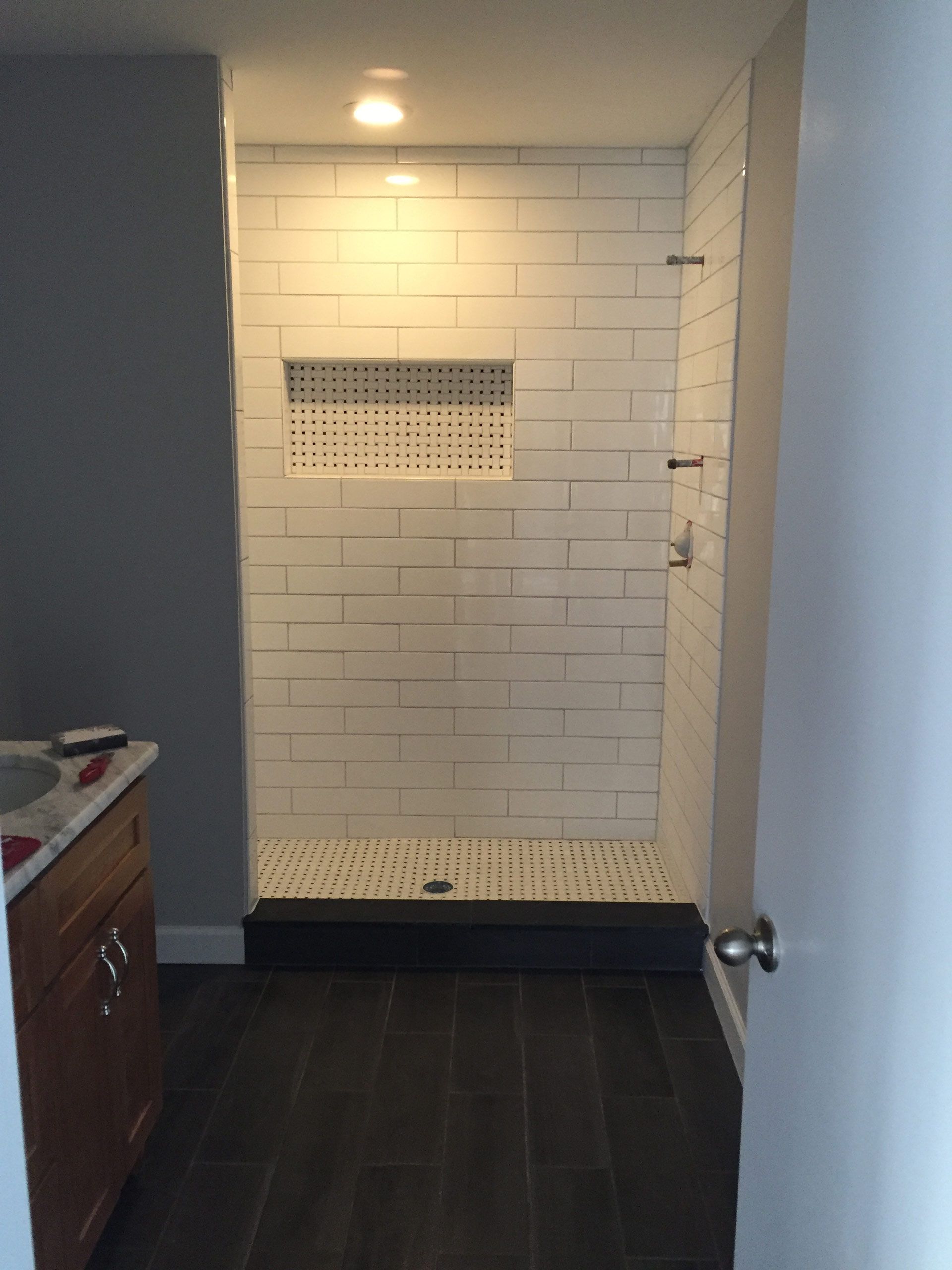A bathroom with a walk in shower and a sink