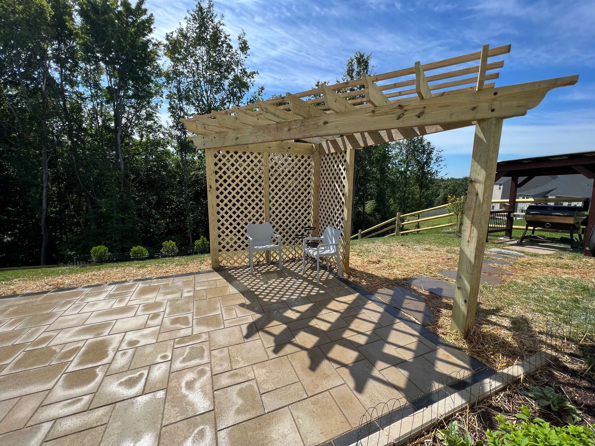 A wooden pergola is sitting on top of a patio.