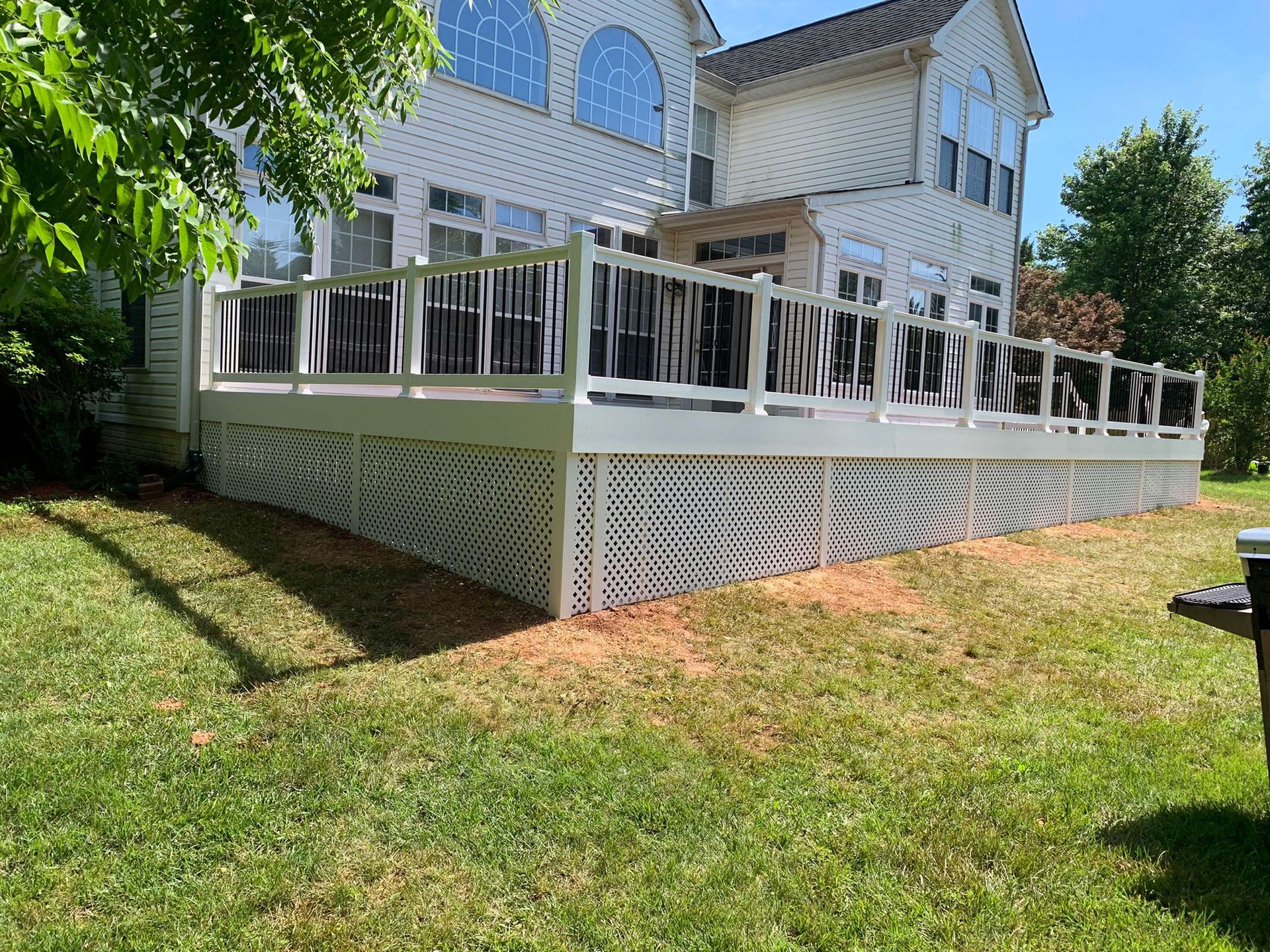 A large white house with a large deck in front of it.