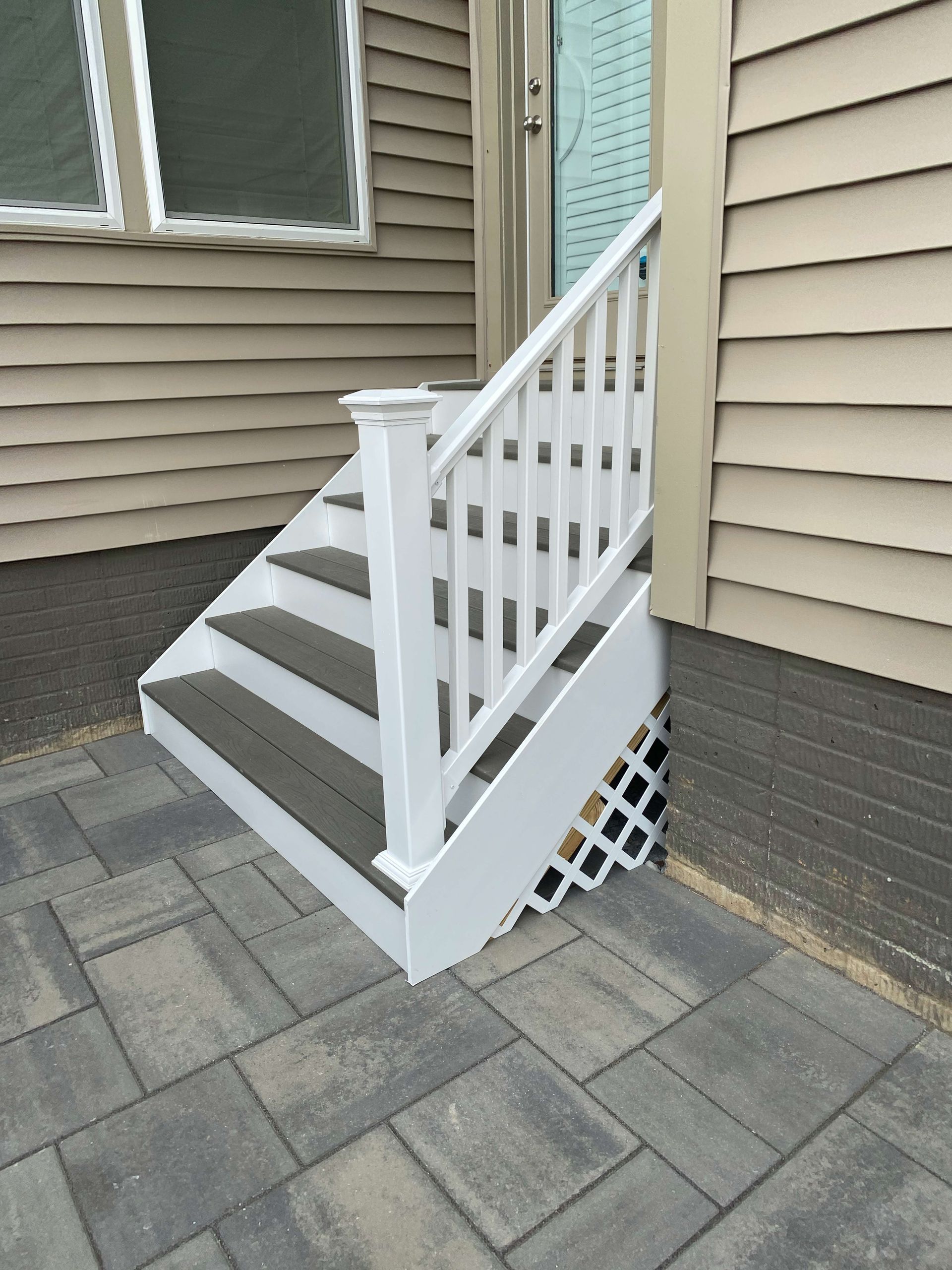 A set of stairs leading up to a house with a white railing