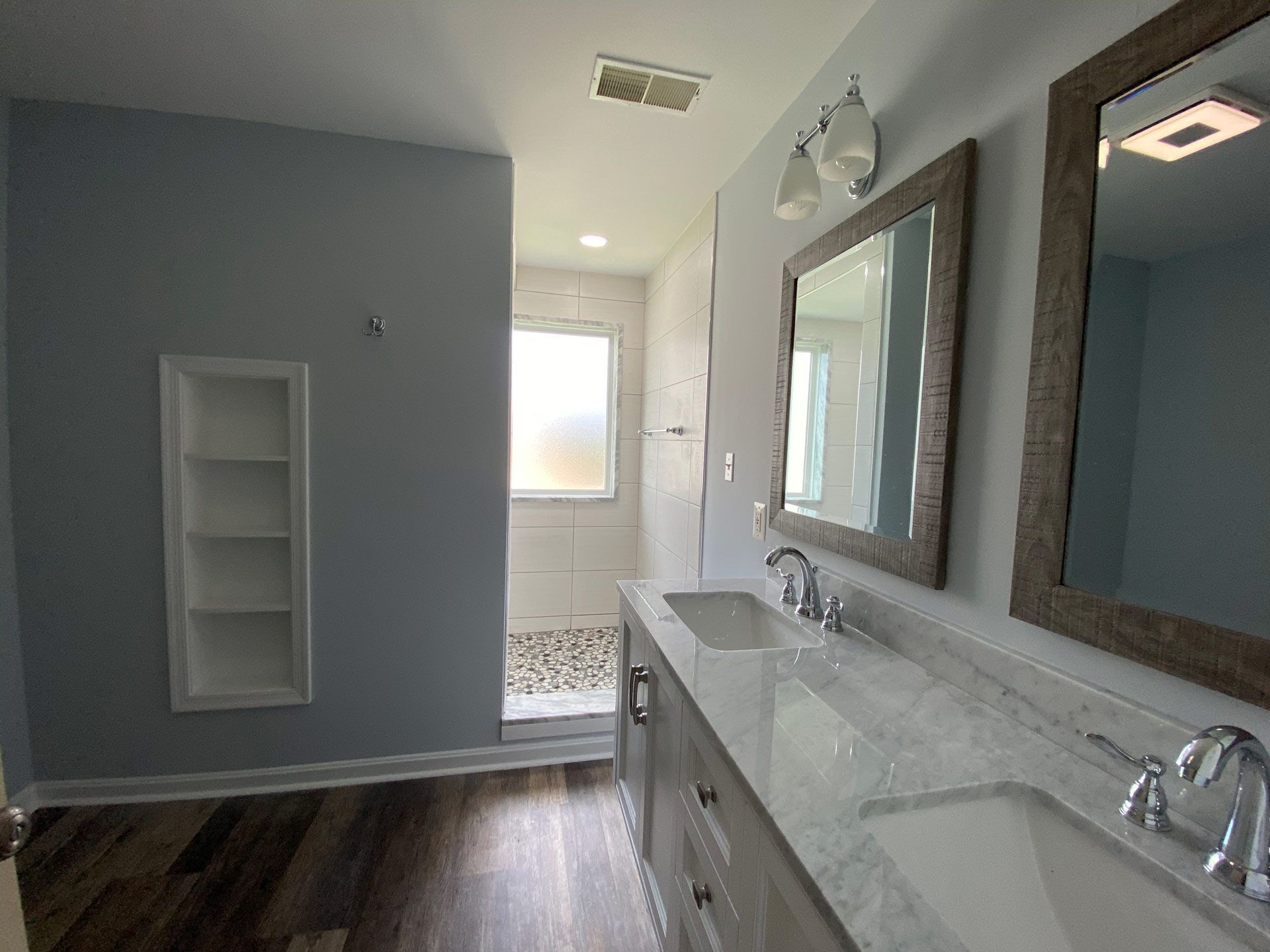 A bathroom with two sinks and two mirrors.