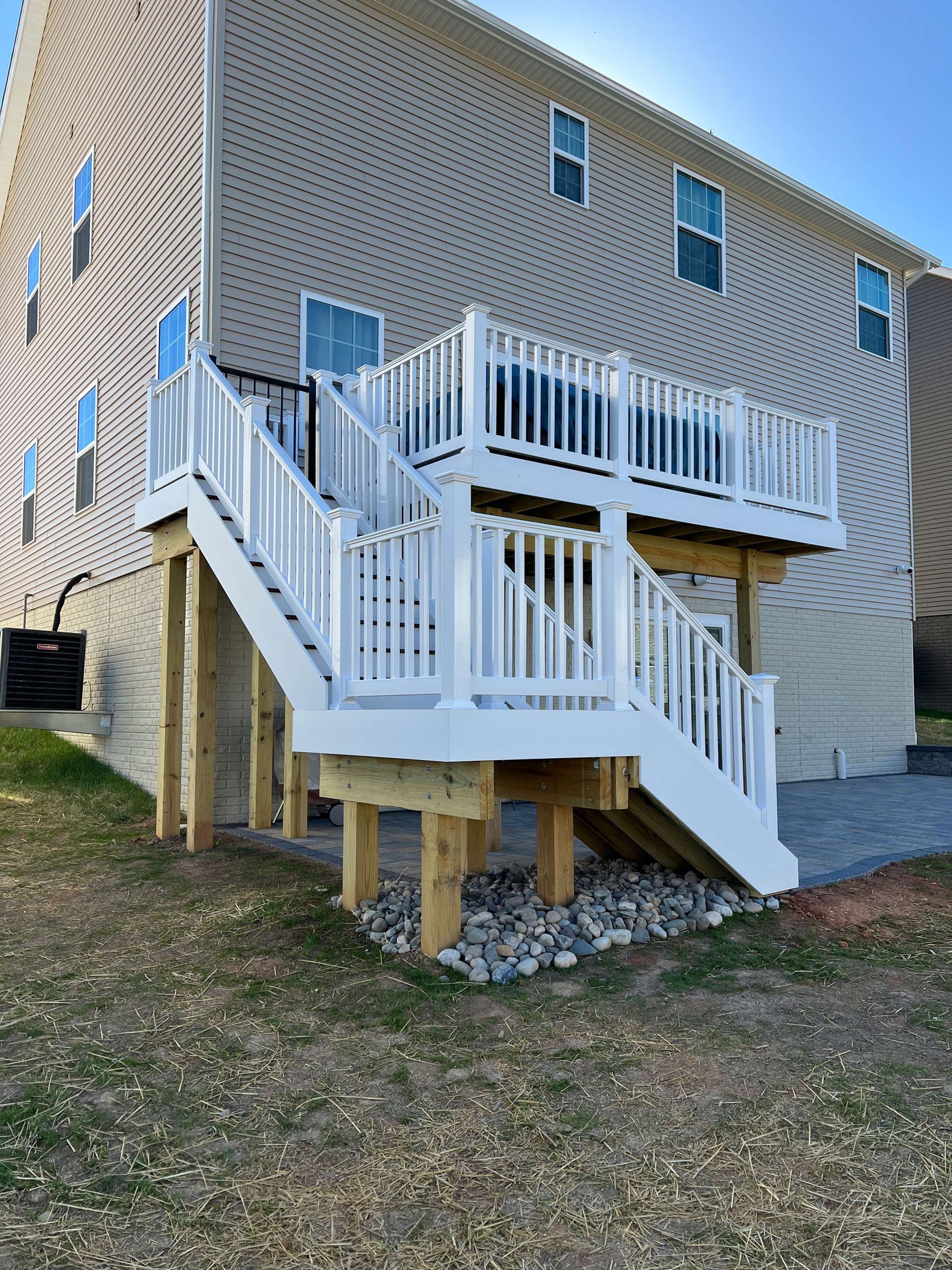 A house with a deck and stairs on the side of it.