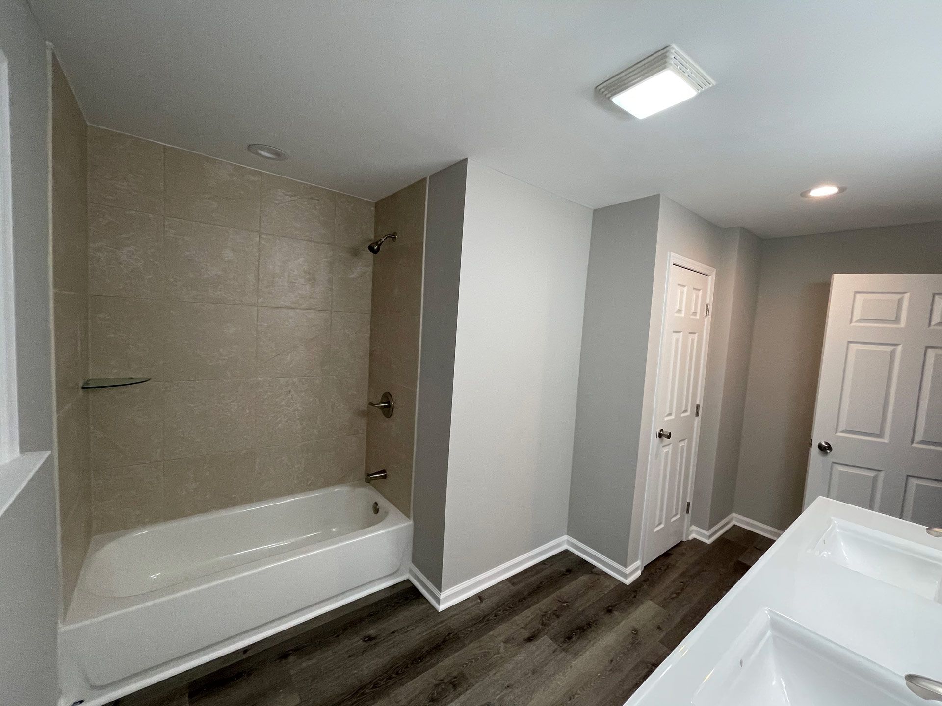 A bathroom with a bathtub , sink and shower.