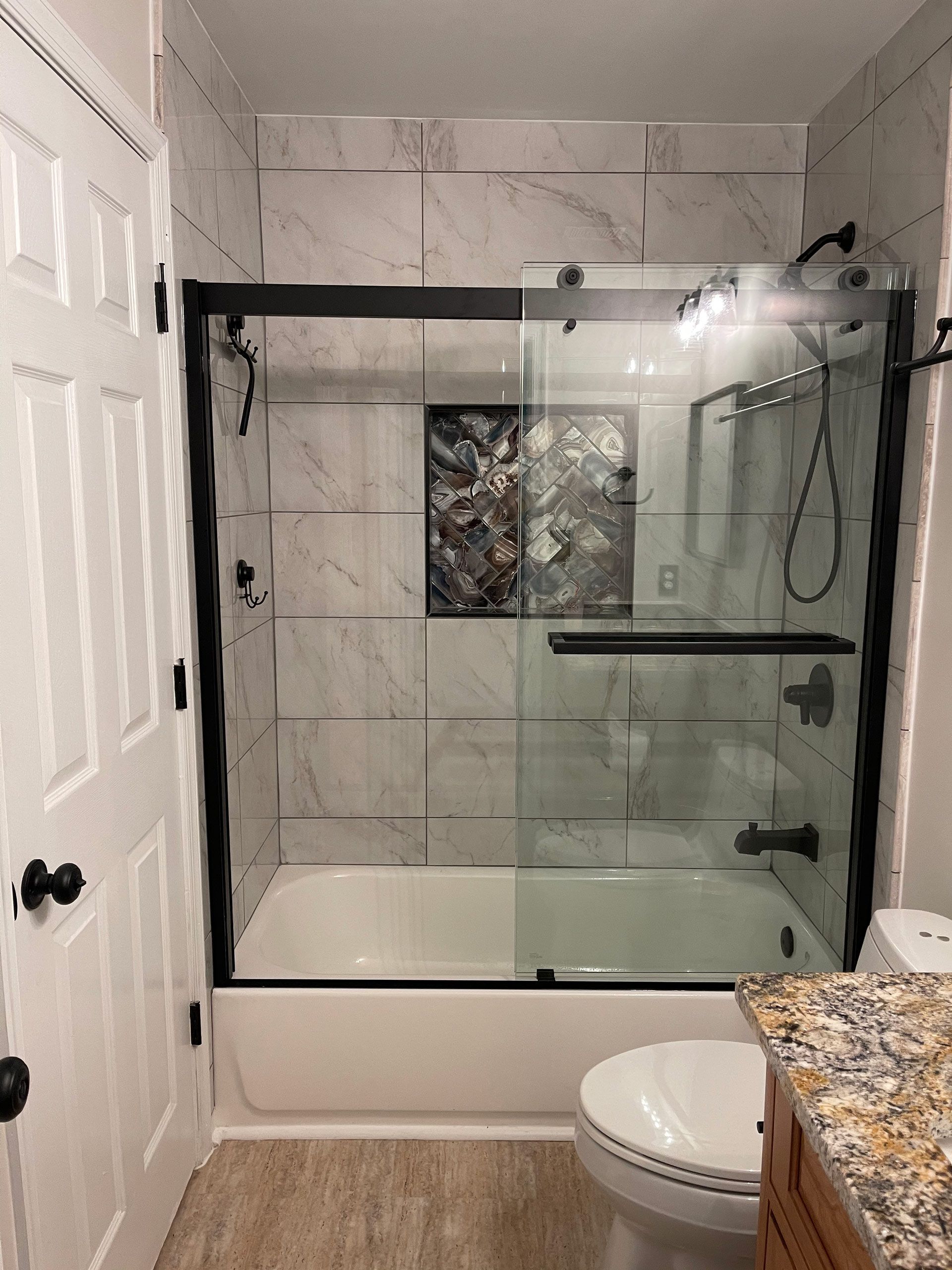A bathroom with a tub , toilet , and shower.