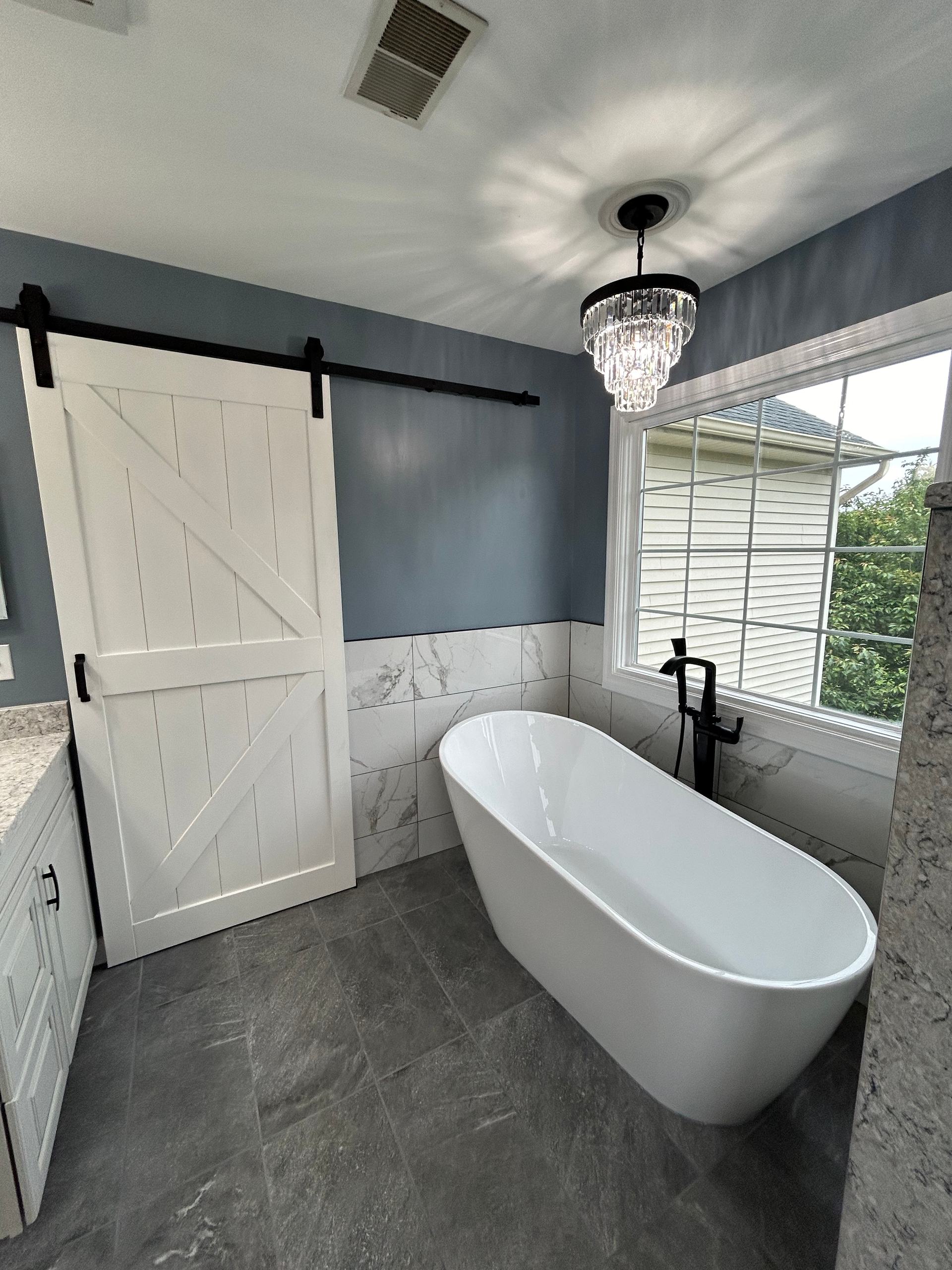 A bathroom with a bathtub and a sliding barn door