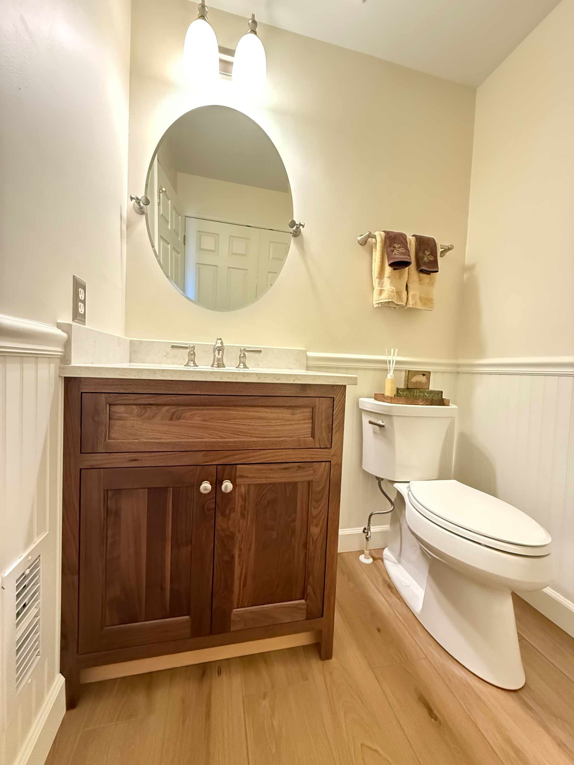 A bathroom with a toilet , sink and mirror.