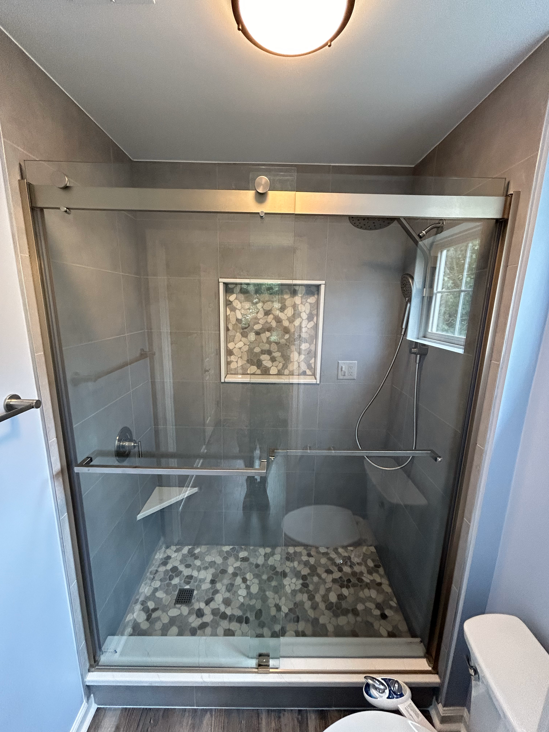 A bathroom with a sliding glass shower door and a toilet.