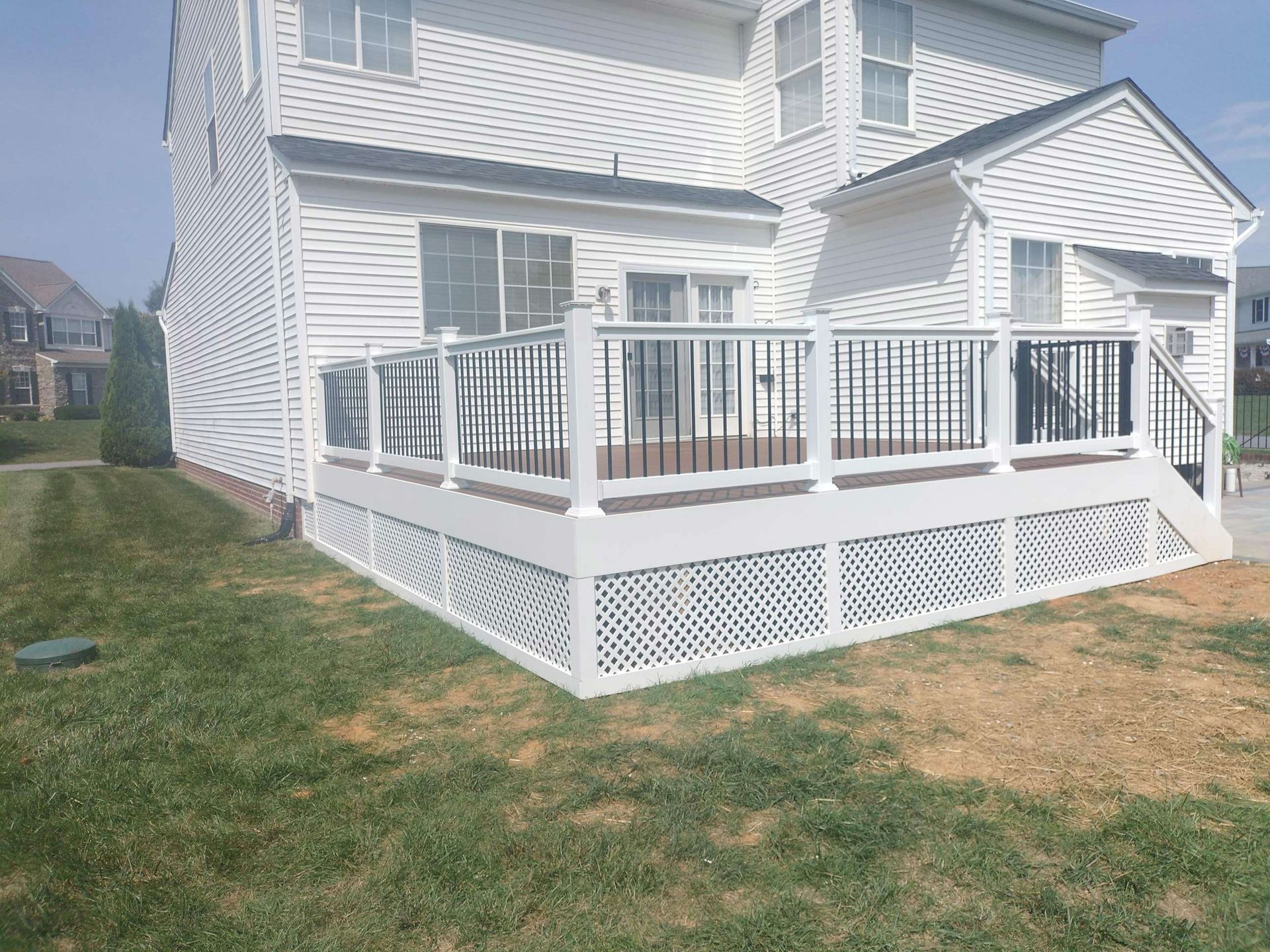 A white house with a white deck and stairs