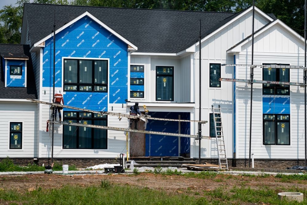 A person is applying caulk to a window frame