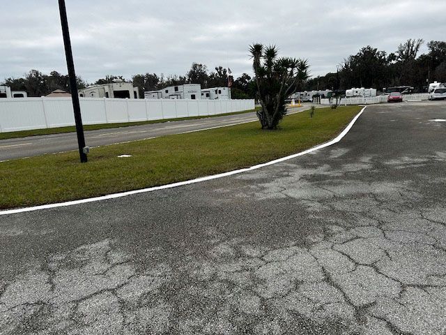 A cracked asphalt road with a white line on it
