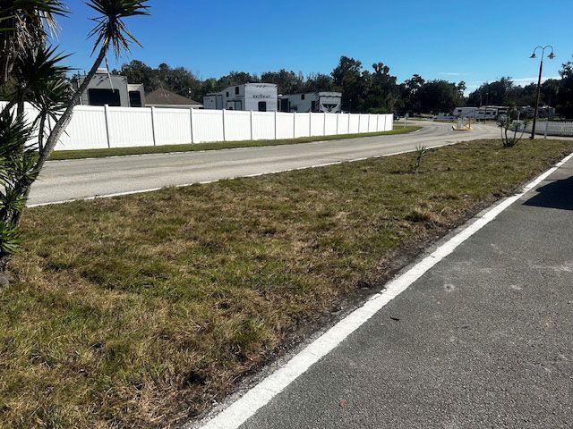 A white fence along the side of a road