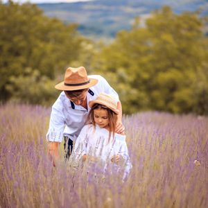 A man and a little girl are standing in a lavender field.