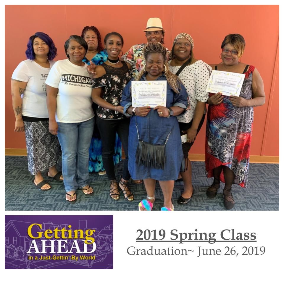 Group of people smiling, holding diplomas.