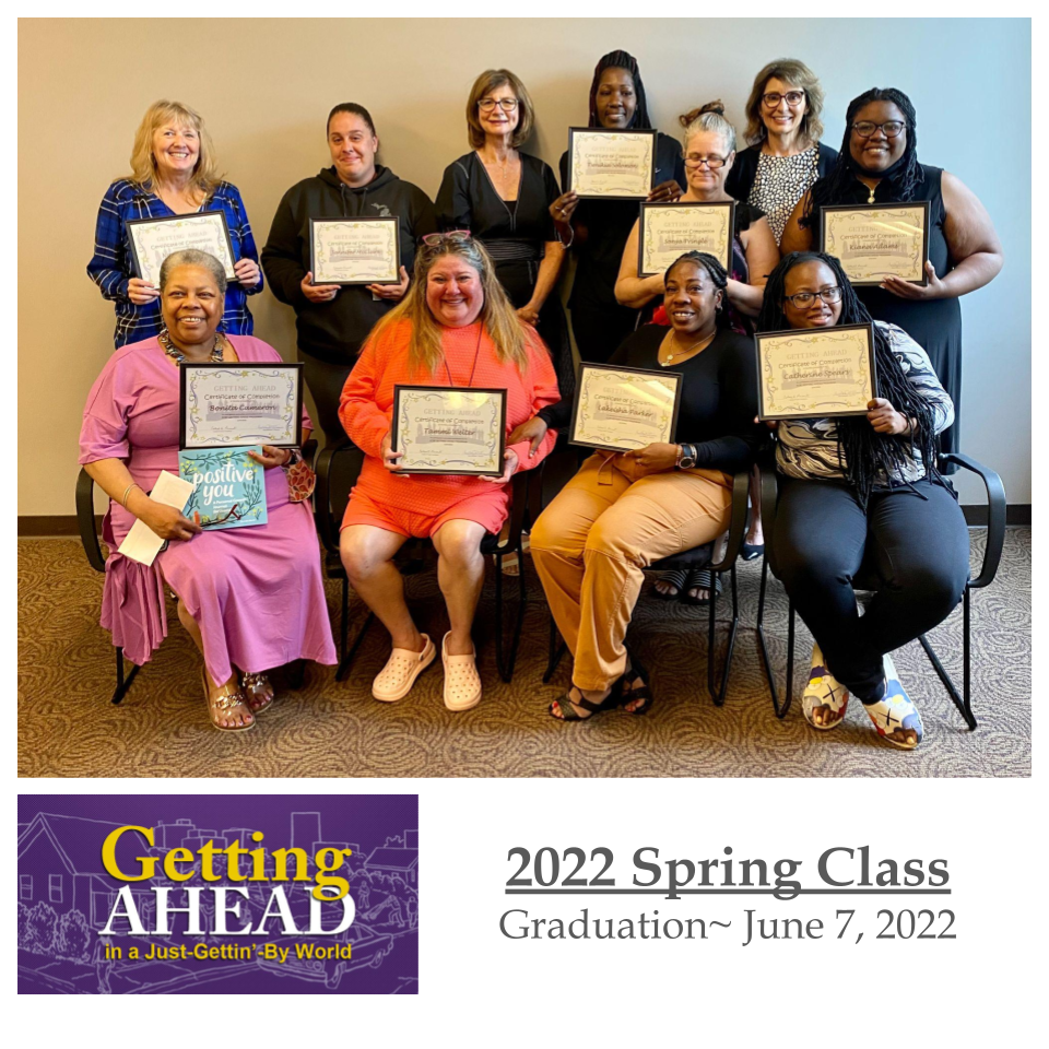 Group of graduates holding certificates;