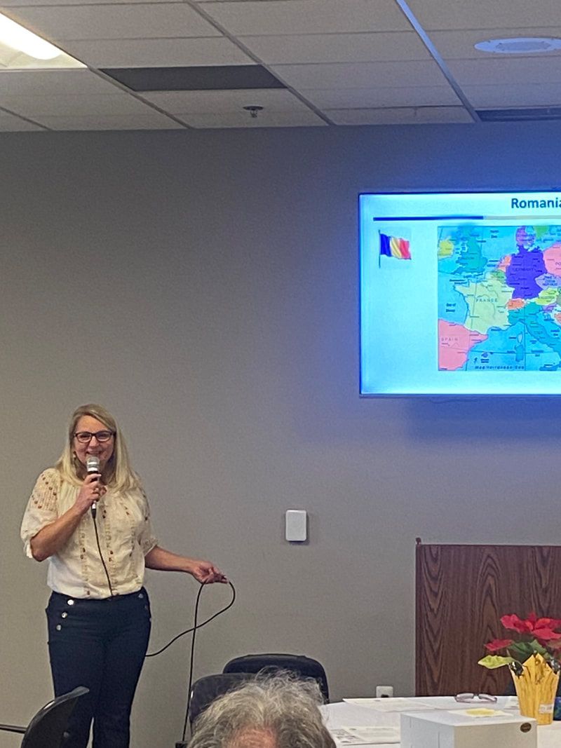 Woman giving presentation on French regions, pointing at a map with the French flag.