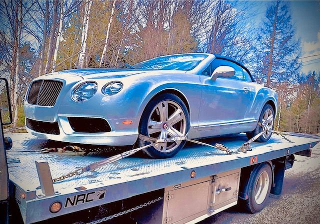 Une Bentley décapotable est remorquée par une dépanneuse.