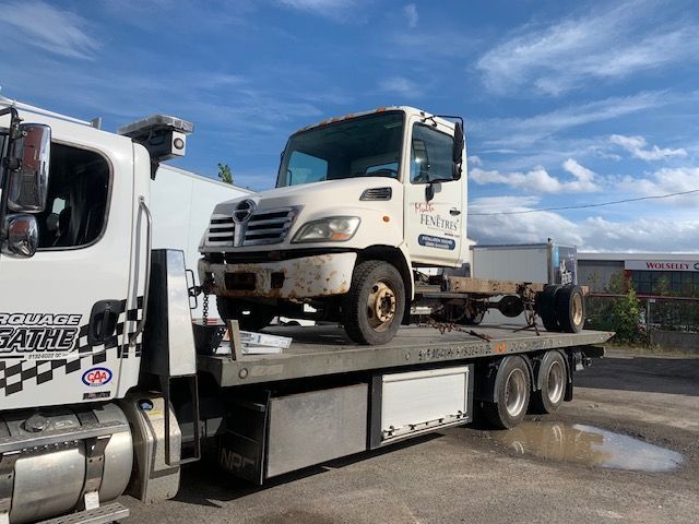 Une dépanneuse avec un camion à l'arrière.